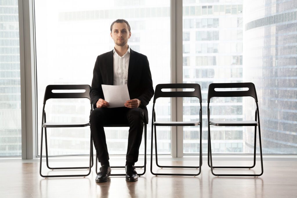 Candidate on post sitting on chair with resume